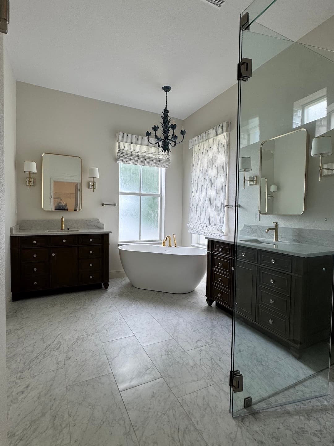 Bathroom with freestanding tub, dual vanity, and chandelier in Tampa