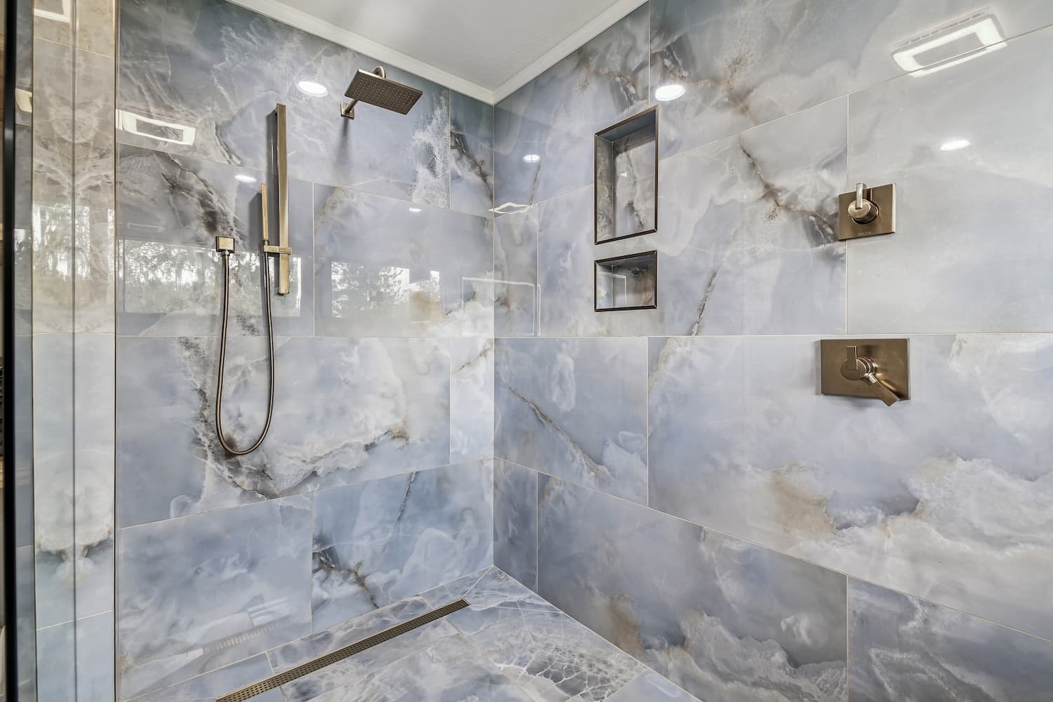 Blue marble walk-in shower with brass fixtures