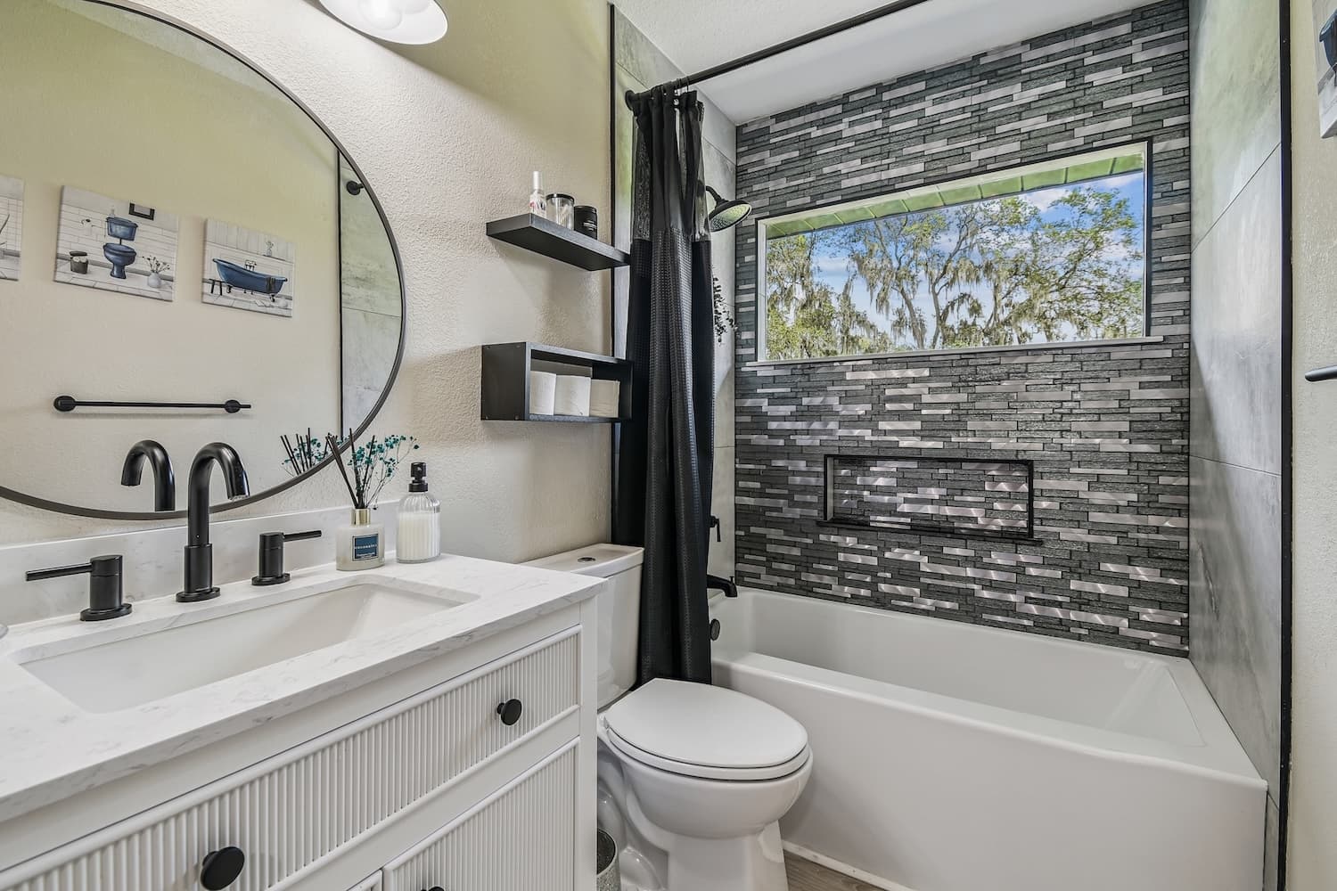 Bathroom with round mirror and stacked tile
