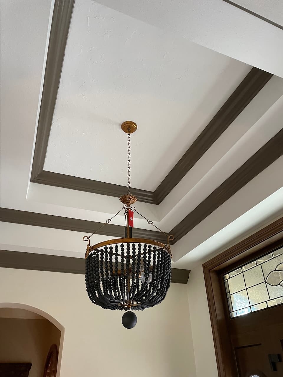 Entryway ceiling detail with black chandelier