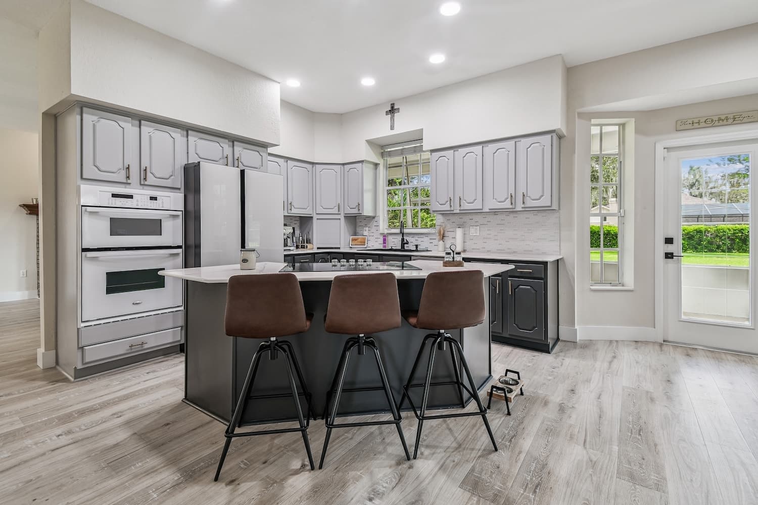 Modern Tampa kitchen renovation with gray two-tone cabinets, center island, and bar stool seating