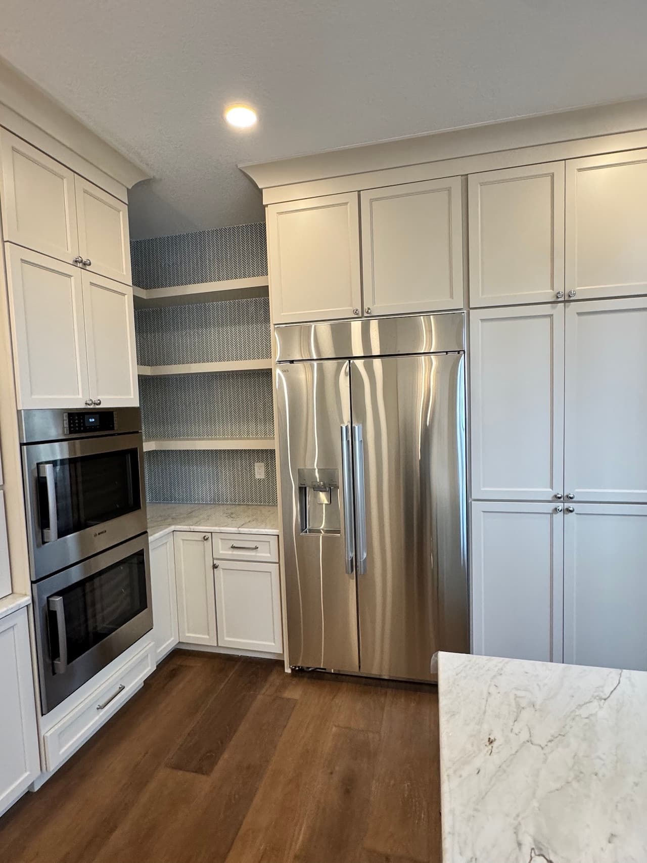 Kitchen remodel with white cabinets and stainless steel appliances in Tampa